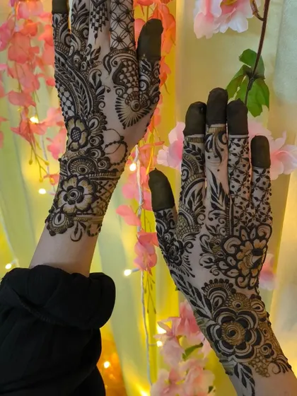 A modern floral design with bold, dark fingertips. The contrast between the filled tips and the detailed patterns creates a striking look.