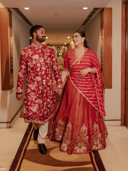 The couple walking hand-in-hand. This shot of Aashrita and Divyajeet captures a simple, happy moment from their Mehendi celebration, showcasing their connection.