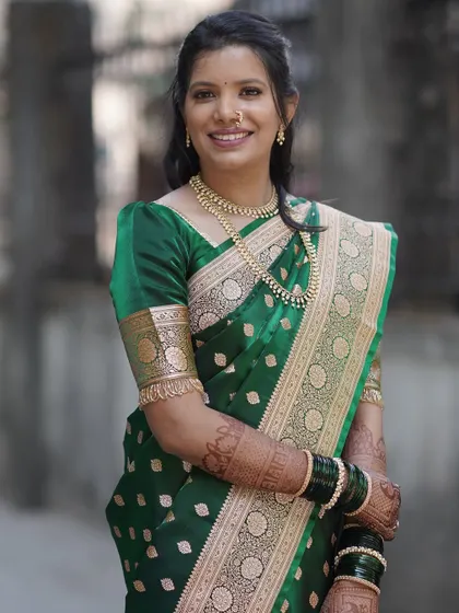 Elegance personified for an engagement ceremony. This client is glowing in a classic green silk saree, with natural-looking makeup and a simple hairstyle that highlights her happiness.