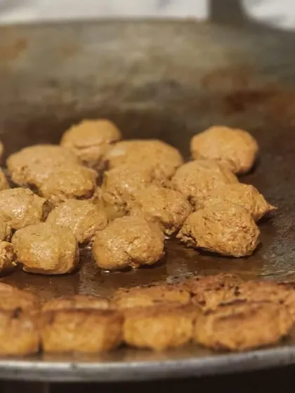 A close-up of galouti kebabs sizzling on a traditional tawa at one of our live cooking stations. We focus on using authentic cooking methods to deliver the best flavor for classic Indian dishes.