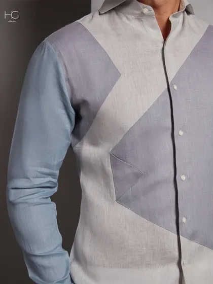 This is bespoke style for the modern man. The geometric color-blocking in shades of blue and grey on this linen shirt creates a visually striking yet sophisticated piece.