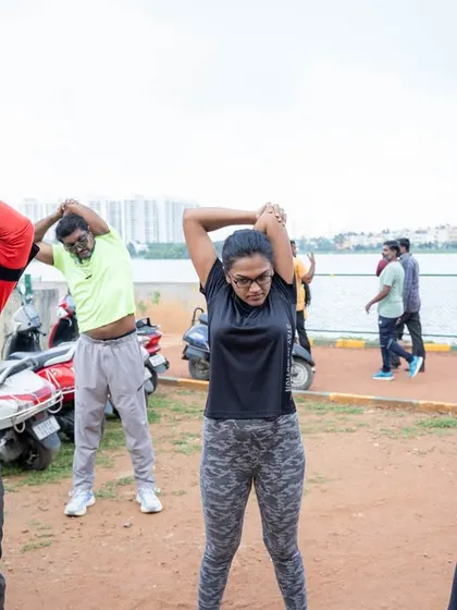 More participants stretching by the lake, highlighting the importance of a proper warm-up.