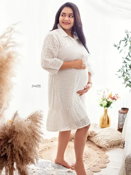 A casual white dress can be just as stunning for a maternity shoot. This candid shot captures a moment of pure joy, with the soft, bright light of my boho corner creating a dreamy feel.