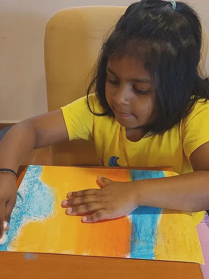 Another angle of our oil pastel seascape class, showing a student's concentration as she blends the colors of the sky and sea.