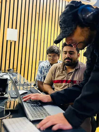 Another angle of our hands-on production course, showing a mentor guiding a student through a project on the laptop.