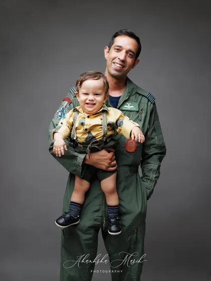 A happy and playful portrait of a father and his son. The little boy's cheerful wave makes this an especially lively and memorable shot.