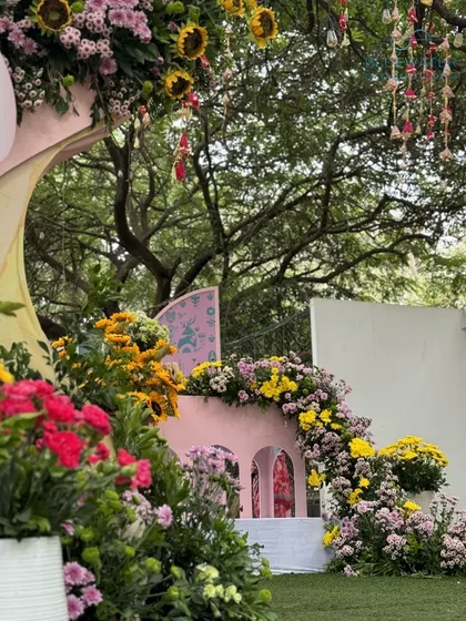 A cascade of flowers adorns a whimsical pink archway structure.