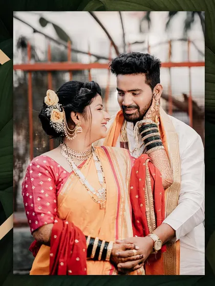 A candid moment of love and laughter. The bride looks lovingly at her groom, her smile radiant in her traditional orange and red Nauwari saree.