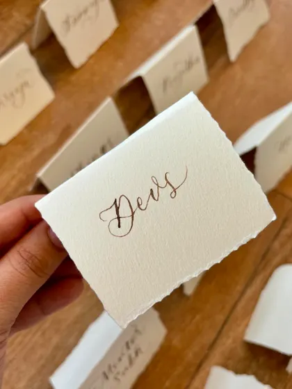 Freehand modern calligraphy on deckled edge place cards is the perfect accompaniment to a sit-down dinner. The torn edges of the handmade paper add a rustic and organic feel.