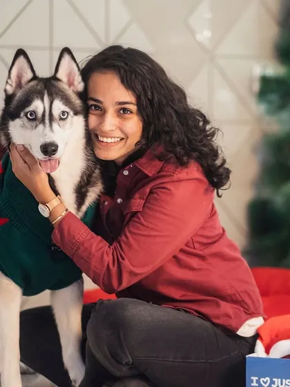 A heartwarming hug between a beautiful Siberian Husky and his owner during a Christmas campaign shoot. The genuine affection between them shines through in this photo.