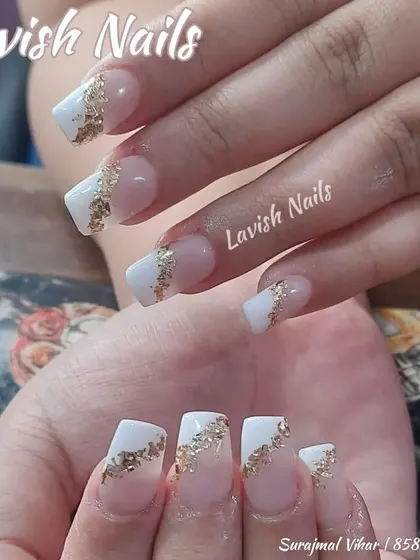 A modern take on the French manicure with a white tip and a dramatic slash of gold foil on a clear base.
