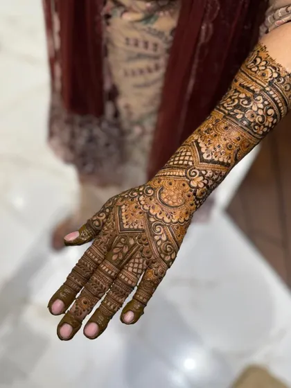 This image shows a detailed bridal design on the palm and arm, featuring a mix of geometric and floral elements.