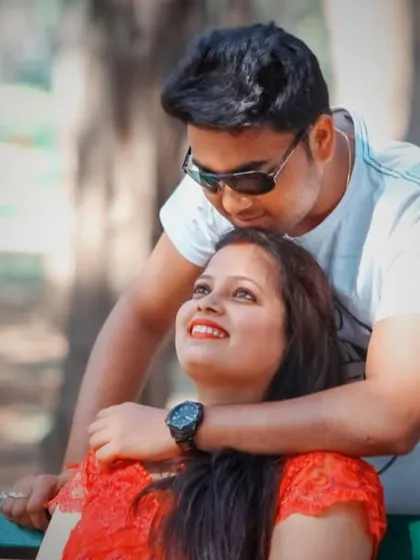 A candid and affectionate moment captured on a park bench during a casual pre-wedding photoshoot.