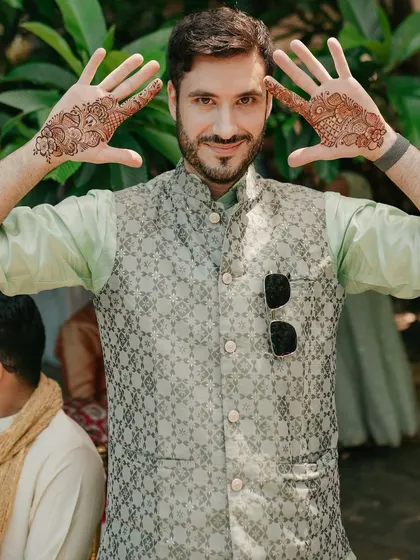Another guest proudly displays his intricate Mehendi design.