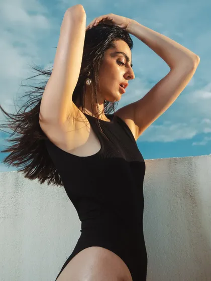 The movement in this shot highlights the natural, windswept hair and the way the light catches the glowing skin.