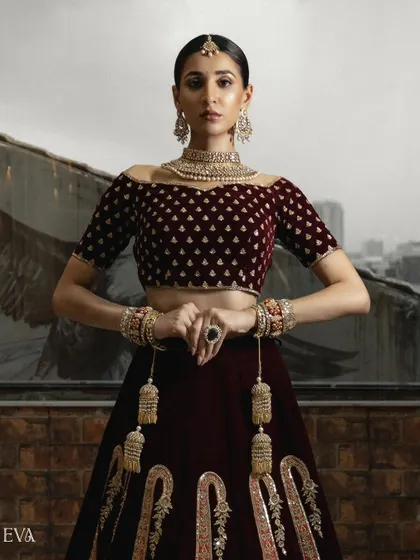 A powerful, centered shot of the model in a full bridal lehenga. The composition emphasizes the symmetry and richness of the traditional Indian bridal wear.