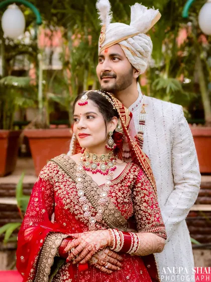 A candid-style portrait of the couple looking away from the camera. This captures a quiet, shared moment between them amidst the wedding day festivities.