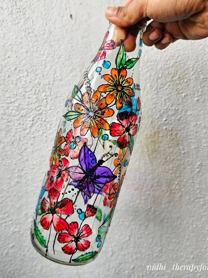 A full view of the vibrant floral and butterfly bottle, showing the lively mix of colors and shapes. It’s like holding a summer garden in your hands.