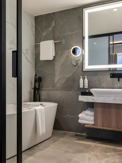 A tranquil bath space featuring a freestanding tub, visible through sliding doors from the main room. This design choice creates a sense of openness while offering a private area for ultimate relaxation.