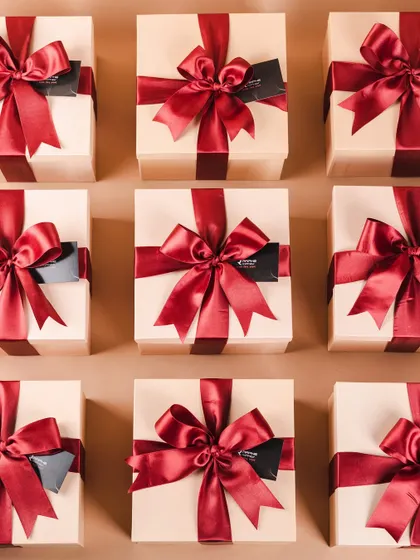 A stunning array of premium gift boxes for our client RAPHE, tied with a rich, deep red satin ribbon. This is luxury gifting at its finest.