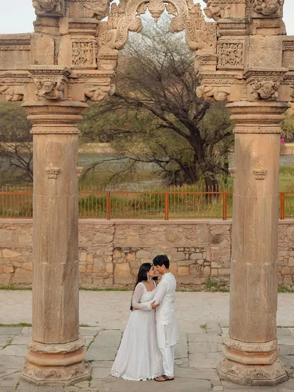 Framed by historic pillars, this intimate moment feels like a scene from a classic romance. We use architectural elements to create depth and narrative in our pre-wedding photography.