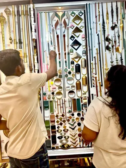 Helping a client choose the right hardware. Here, we are looking at a vast selection of designer door handles to find the perfect match for their home's aesthetic.