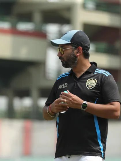 A candid shot of our coach on the sidelines, focused and strategic. This is the mind behind many of our victories.