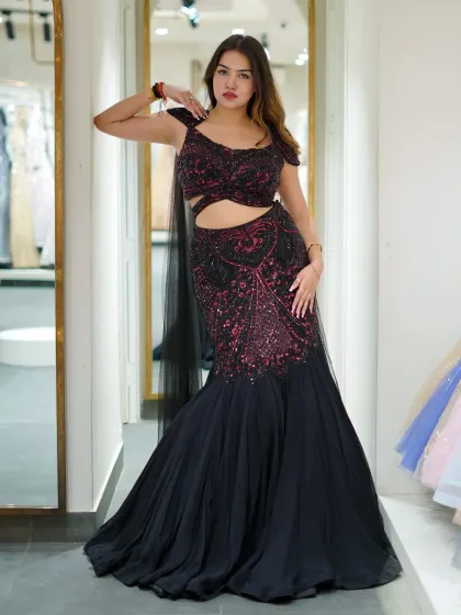 This black and pink fish-cut lehenga is designed to turn heads. The cutout details at the waist and the contrasting embroidery make it a unique and edgy choice for a modern event.
