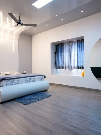 This futuristic bedroom design features a sleek, curved bed with integrated lighting. The circular cutout in the wall for the vanity and the unique ceiling lights create a space that is modern, dynamic, and truly one-of-a-kind.