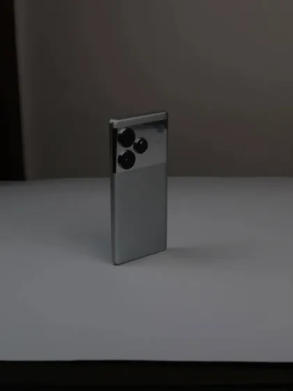 A behind the scenes look at the simple setup for the realme GT6 product shoot, showing the phone on a white surface before the final edits.