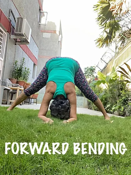 Practicing a wide-legged forward bend on the grass. The uneven surface adds a small balance challenge while enjoying the outdoors.