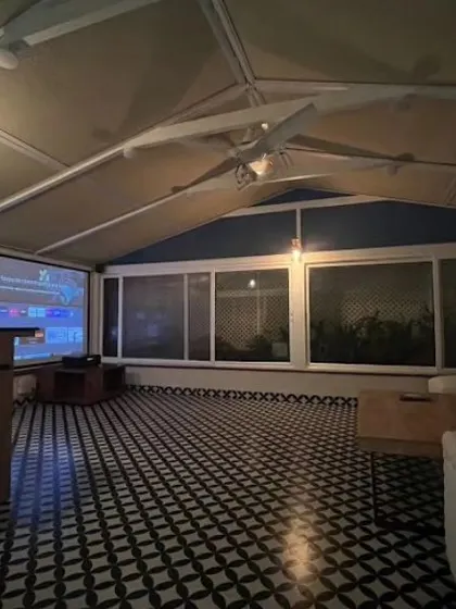 A stylish and functional sunroom on a terrace, designed for Mr. Amar Nagaram. This space features striking Moroccan tiled flooring and retractable remote-controlled blinds, making it a perfect home theater or lounge area.