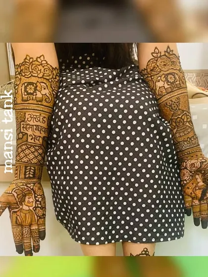 A full view of the bride showing off her detailed henna. The design includes portraits, elephants, and the "Akhand Saubhagyavati Bhava" blessing for a complete and meaningful bridal look.