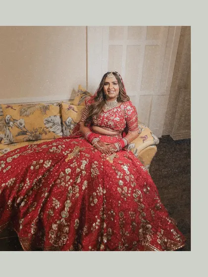 A full-length portrait showcasing the bride's stunningly detailed red lehenga. We ensure that every element of the bridal attire, which is chosen with so much love, is captured beautifully.