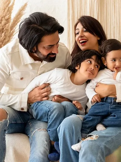 A candid and joyful family portrait session in my studio. I focus on capturing real laughter and playful interactions, like this moment with the whole family together on the couch.