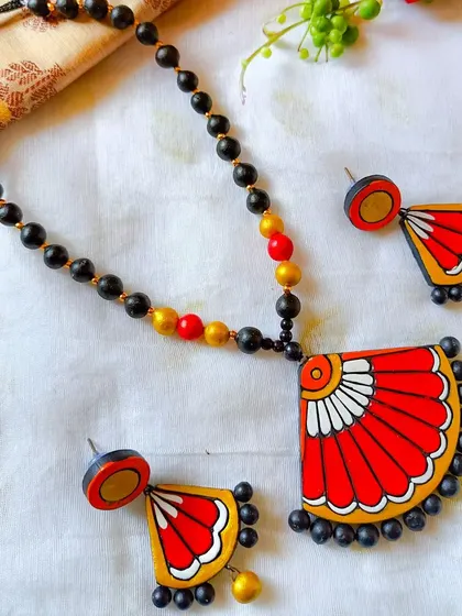 The fan-pendant necklace in a bold red and yellow combination.