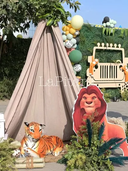 A safari-style camp corner at the Lion King party, with a teepee tent and plush animal toys for kids to play with.