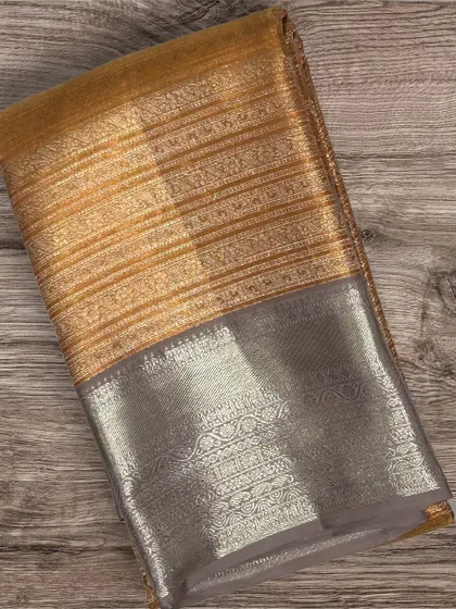 A beautiful Kanchi silk saree with a gold striped body and a silver brocade border.
