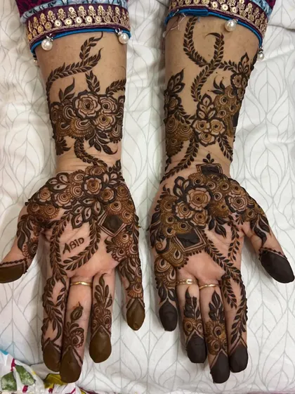 An intricate floral vine design that includes the name 'Abid' cleverly integrated into the pattern on the palm.