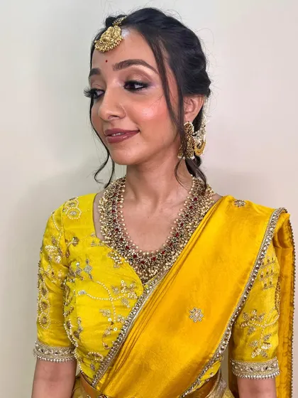 A side profile showing the soft eye makeup and elegant hairstyle. This look is perfect for the bride who prefers a more understated and natural approach.