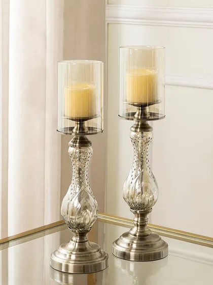 A pair of elegant glass and metal candle stands with a slender, sophisticated silhouette. The subtle detailing on the base and body gives them a classic look that complements a refined decor style.