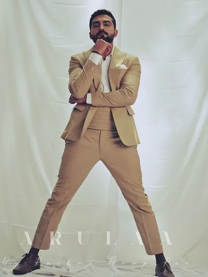A full-length shot showcasing the sharp tailoring and fit of the beige suit. The clean lines and perfect fit create a powerful and confident stance.