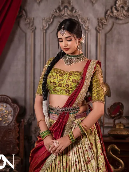 A graceful pose showcasing the full lehenga and Kundan jewellery set. This is a perfect inspiration for anyone attending a wedding or special event.