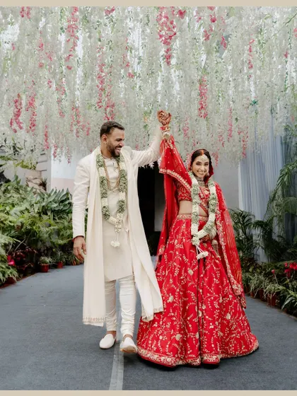 The happy couple after their ceremony. Vidushi's look is a perfect example of a modern North Indian bride, with elegant makeup and a stunning designer lehenga.