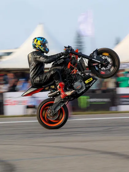 A rider on a KTM Duke performs a high-speed wheelie. The combination of speed and technical skill is what makes stunt riding so exciting to watch.