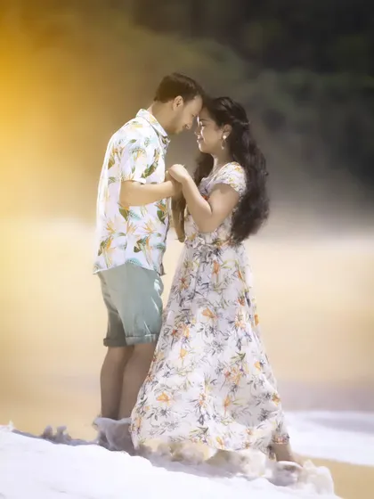 A close-up, intimate portrait from a beach pre-wedding shoot. The soft, golden light enhances the romantic and gentle connection between the couple.