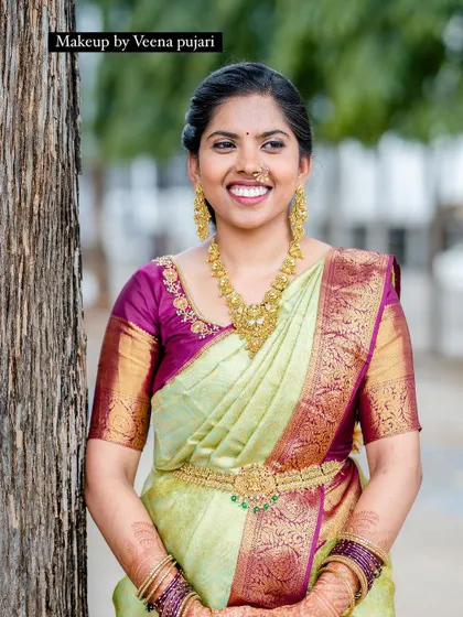 A classic South Indian bridal portrait. The combination of the light green saree, temple jewelry, and radiant makeup is simply timeless.