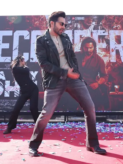 A dynamic shot of Varun Dhawan performing on stage at a movie promotional event. The confetti and high-energy pose capture the excitement we build for brand launches and media events.