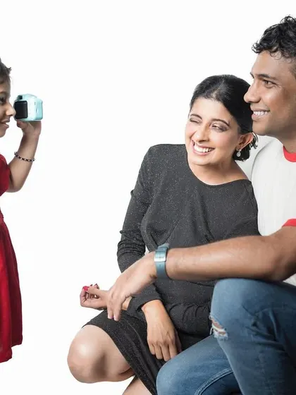 The tables have turned! A little girl takes a photo of her parents, a sweet and funny moment that shows the playful dynamic of their family.