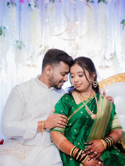 A classic Maharashtrian engagement portrait. The bride's beautiful green Paithani saree and traditional jewelry are complemented by the couple's gentle and happy connection, showcasing a moment of quiet celebration.